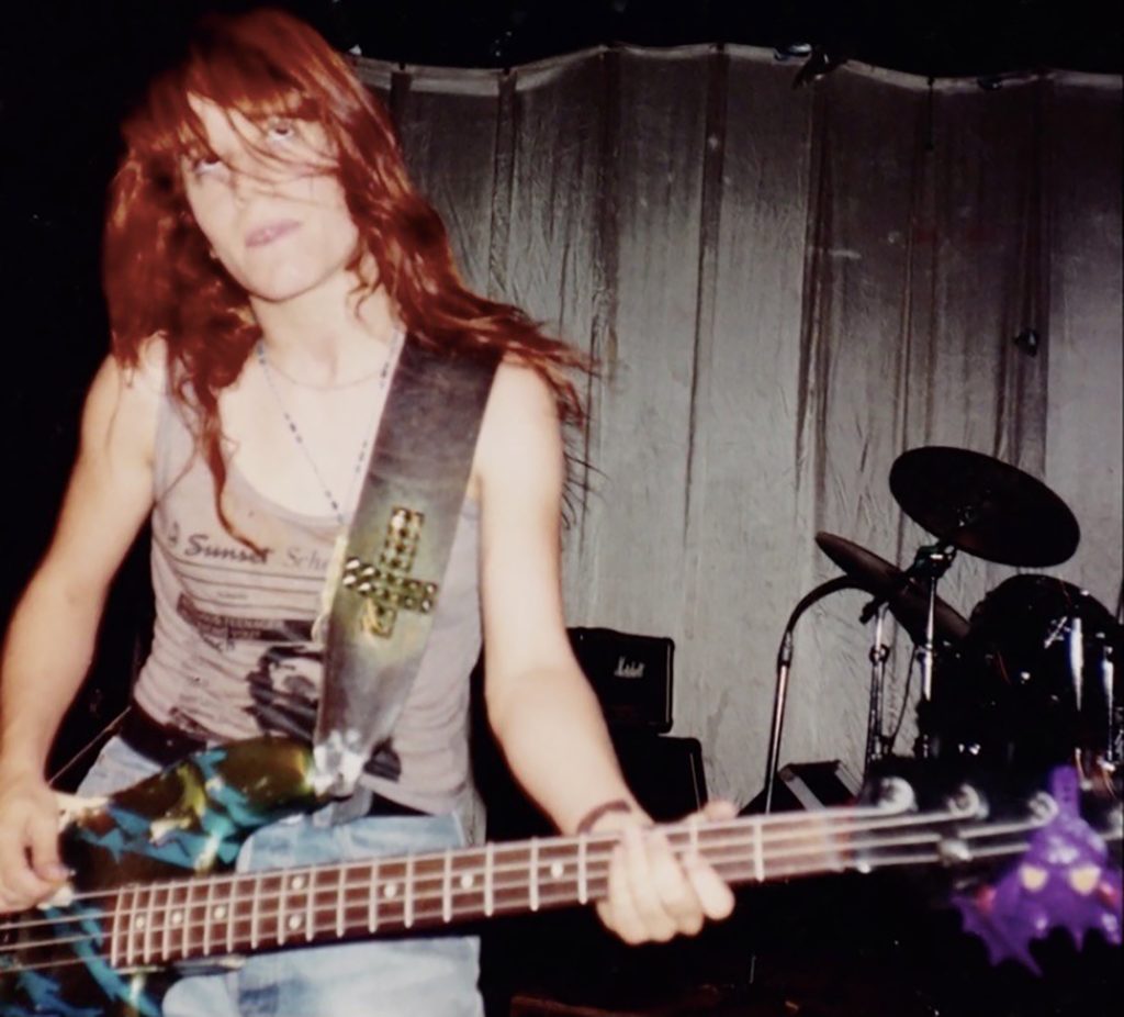 Jennifer Precious Finch performing bass live in studio with L7 and staring at the ceiling