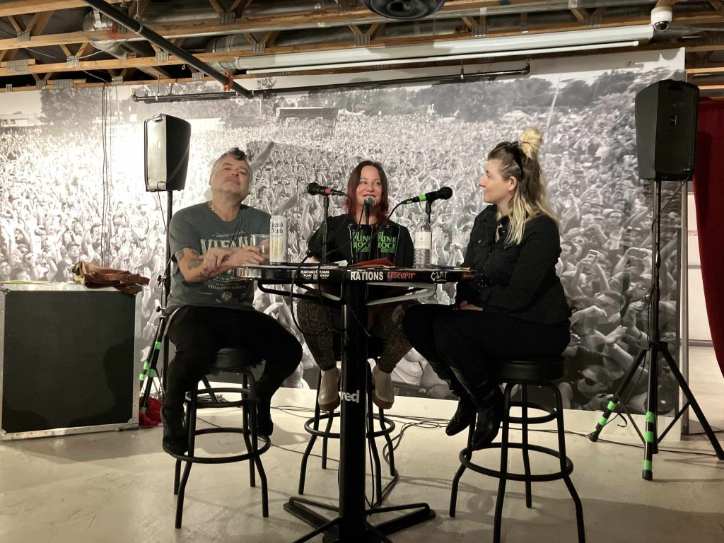 Fat Mike, Jennifer Finch, and Jessica Schwartz sitting at a table for a podcast interview at The Punk Rock Museum