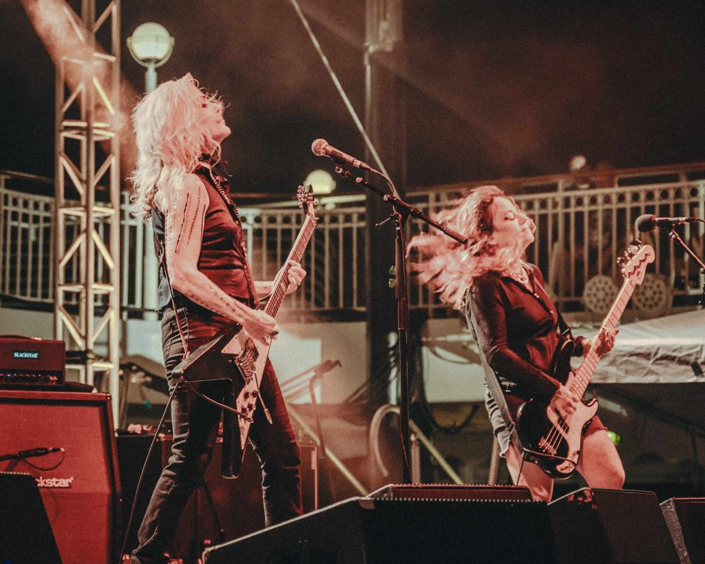 Donita Sparks and Jennifer Finch performing live with a bass and guitar on stage