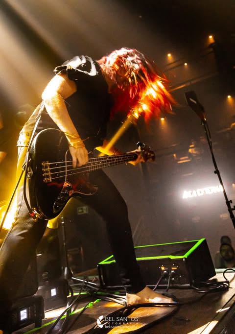 Jennifer Finch with a bass guitar performing live on stage with L7