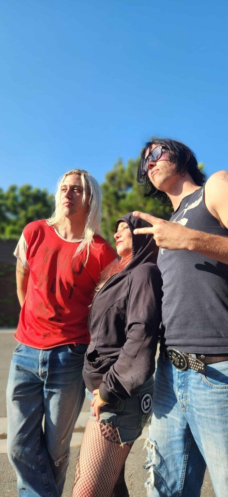 Jennifer Finch posing with members of The Garden outside in Orange County