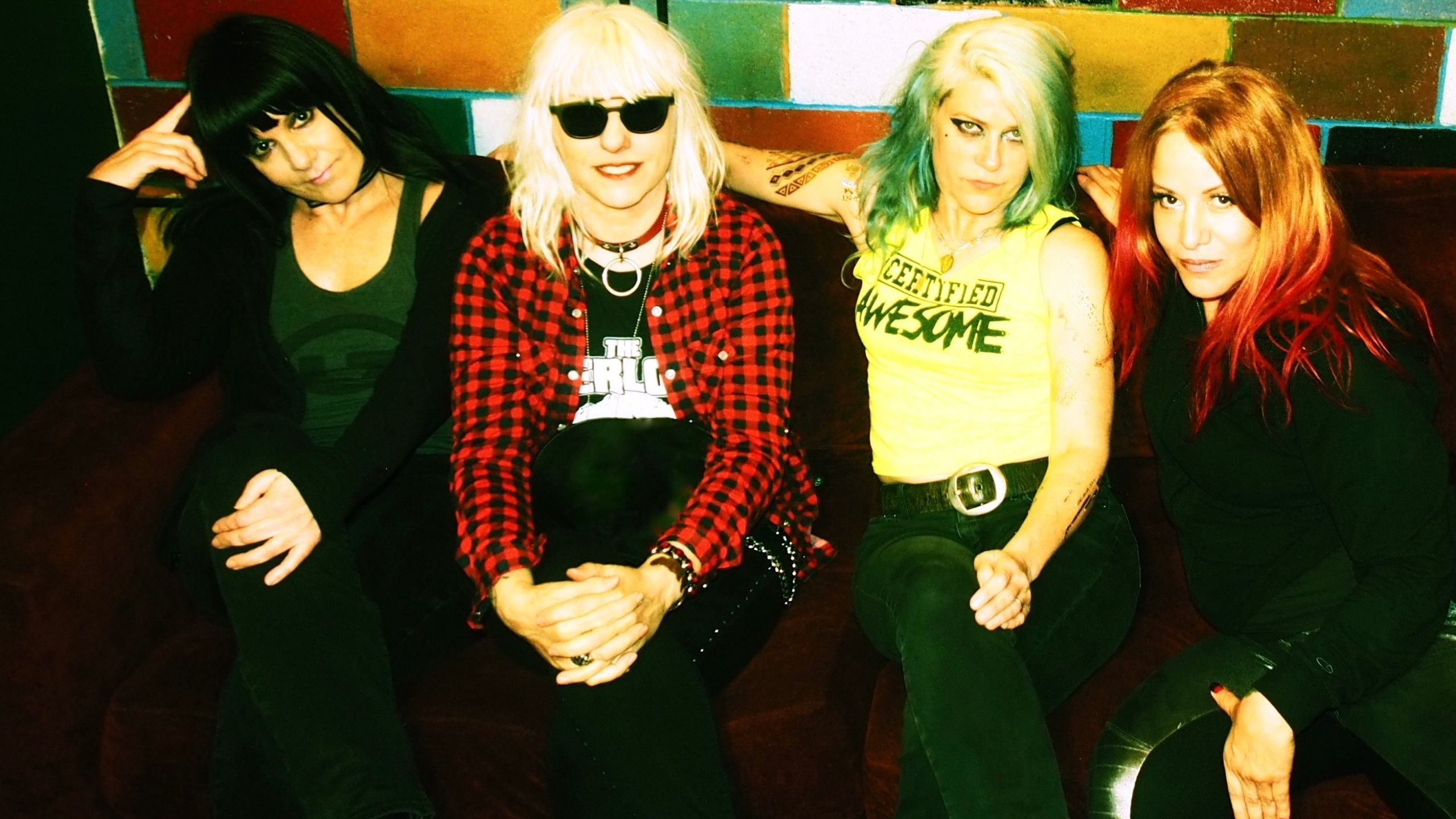 L7 the band sitting down. From left to right - dee plakas, suzi gardner, donita sparks, and jennifer finch
